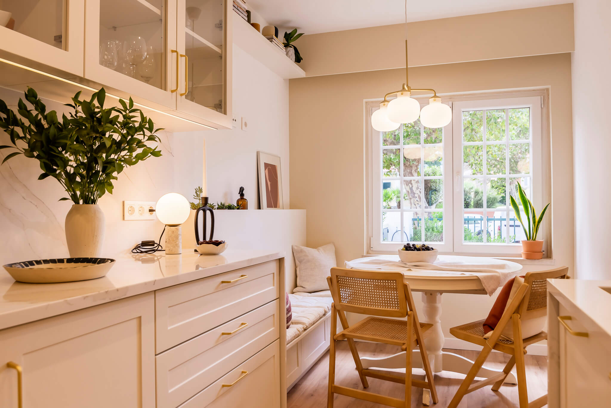 Design de interiores - Cozinha moderna com zona de refeição (breakfast nook) com banco e acabamentos brancos e madeira