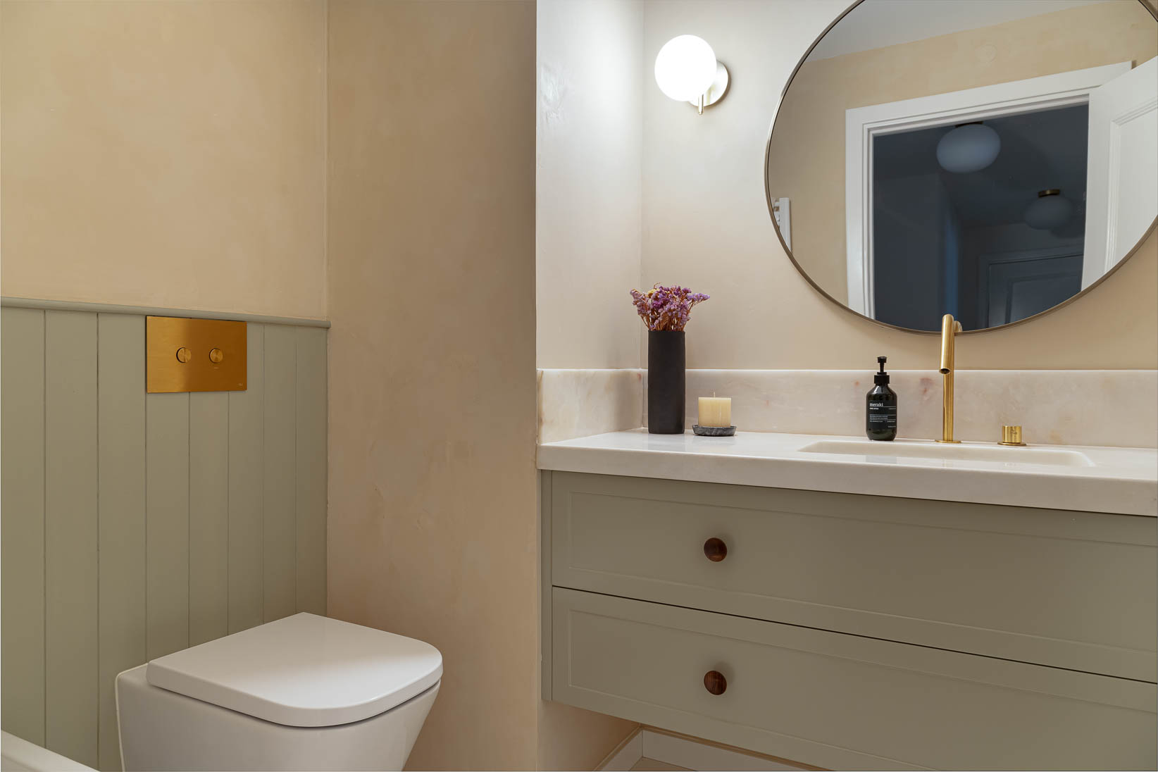 Casa do Paço - casa de banho com móveis em verde claro/ sage green, espelho redondo, e hardware dourado