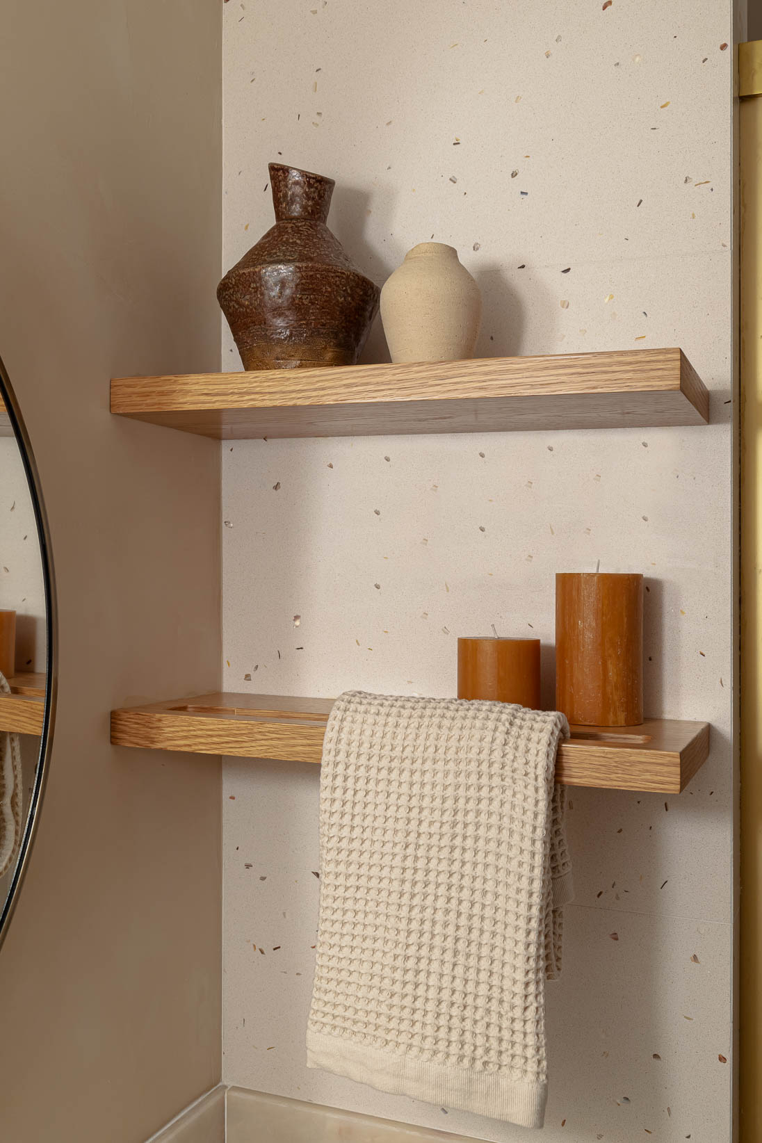 Casa do Paço - casa de banho com móveis em verde claro/ sage green, espelho redondo, e hardware dourado. Estante da casa de banho em madeira natural