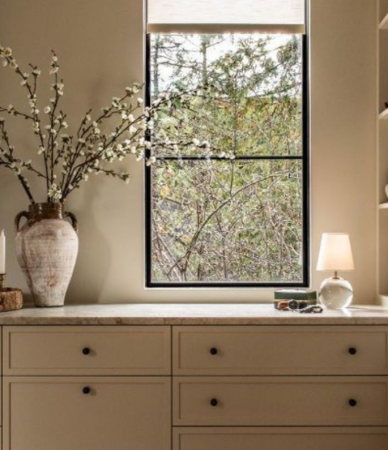 Closet feito por medida, com roupa arrumada em prateleiras e cabides, num ambiente sereno com luz natural.