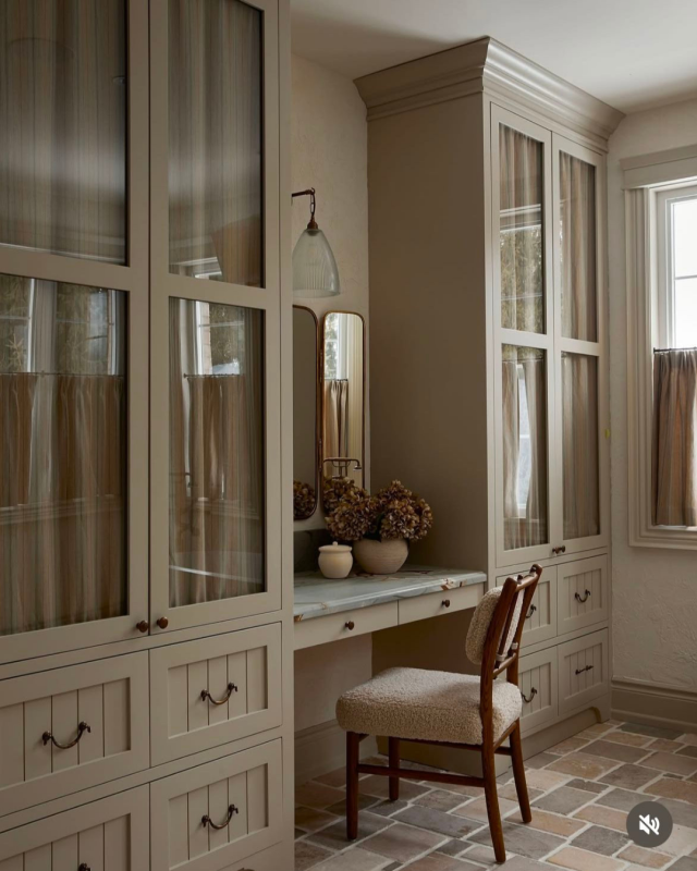 Closet clássico em bege, com armários e gavetas feitos por medida e toucador com bancada em mármore.