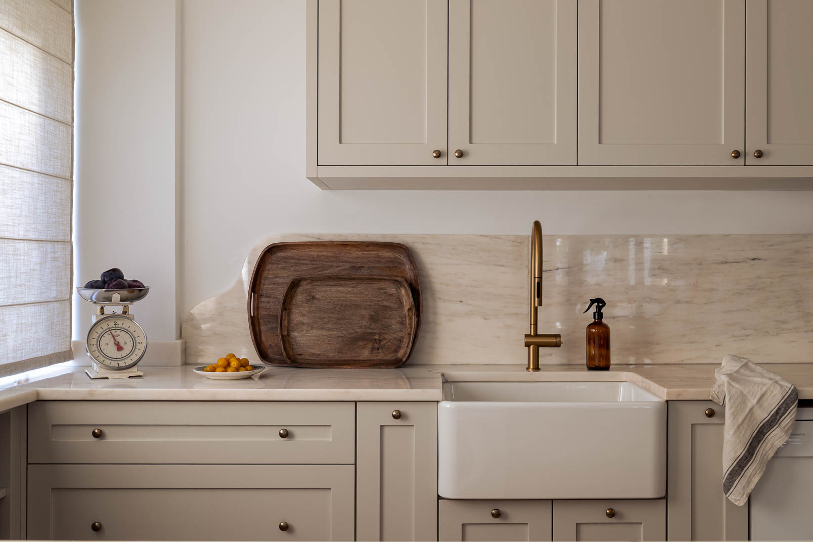 Cozinha com armários lacados por medida e bancada em mármore português