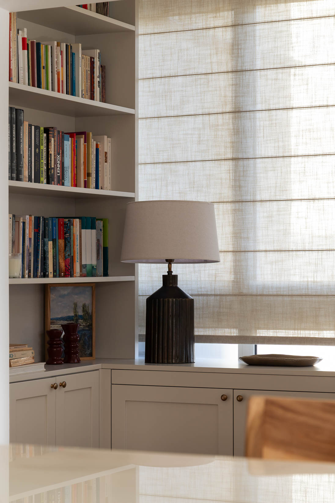 Recanto de trabalho e leitura com estantes e secretária por medida e estores em linho