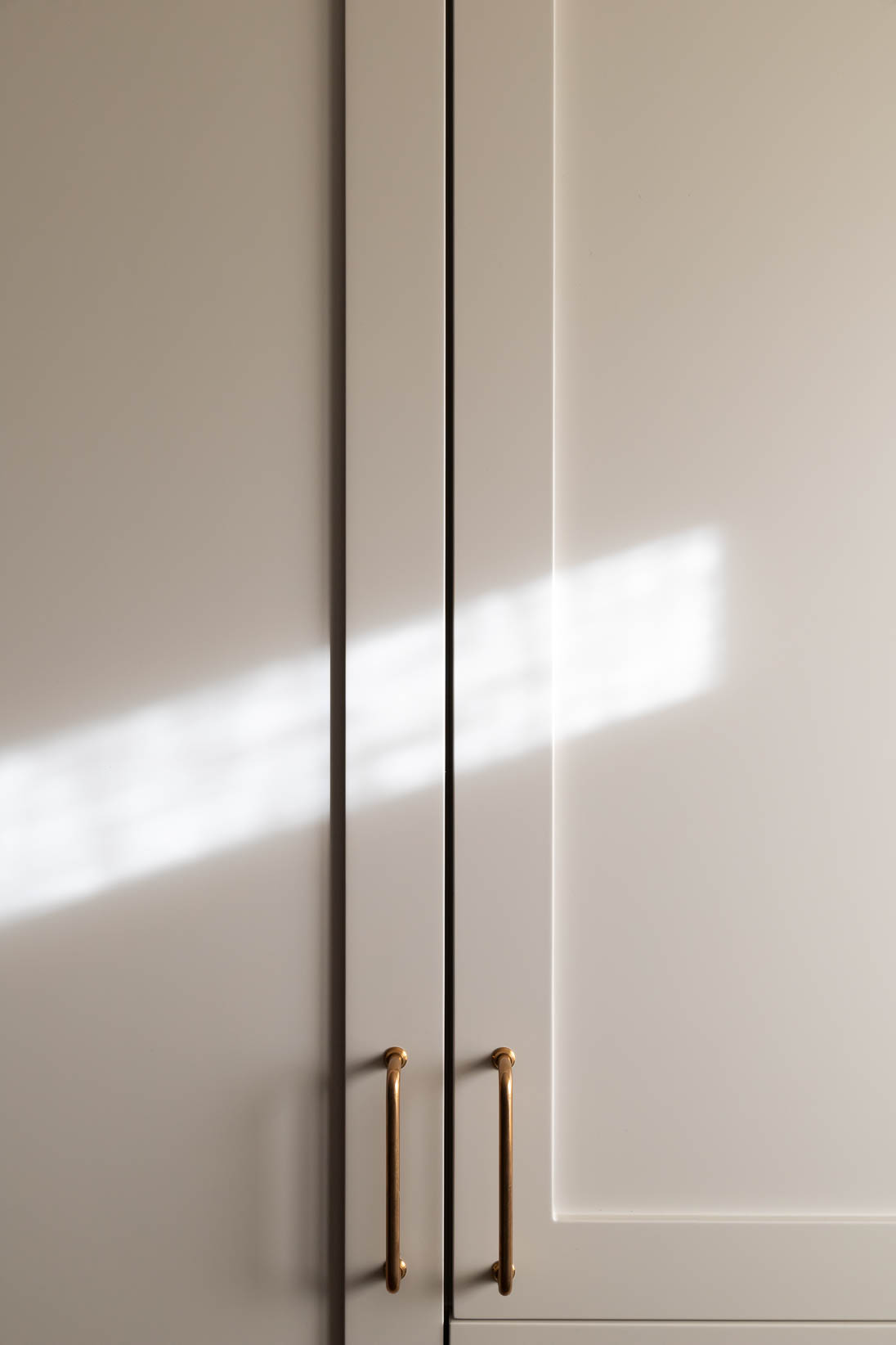 Detalhe de armário de cozinha feito por medida com puxadores em latão