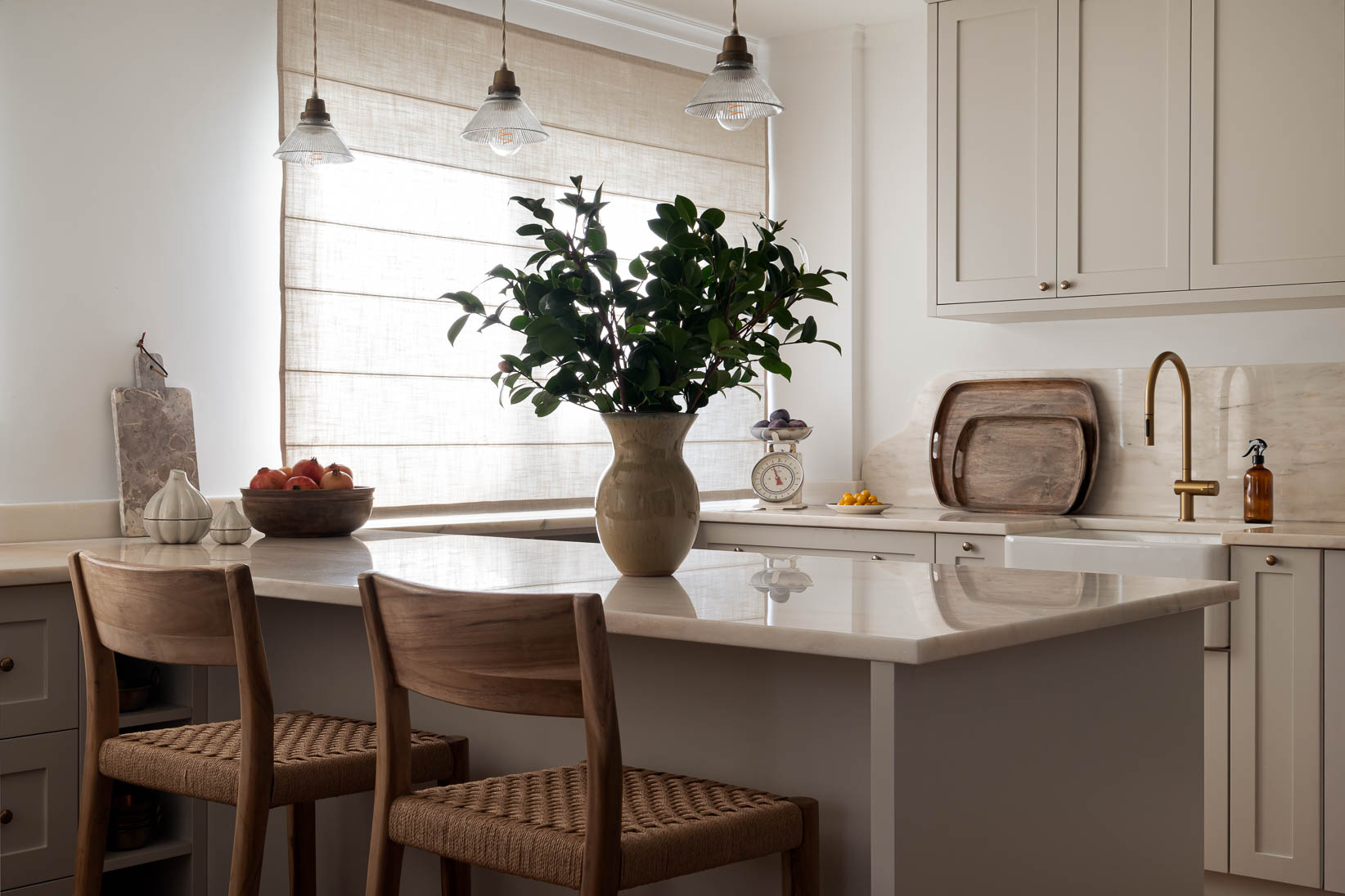 Cozinha aberta com ilha, armários por medida e bancadas em mármore natural